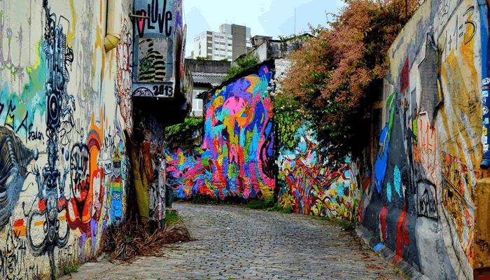 Beco com dezenas de imagens desenhadas nas paredes