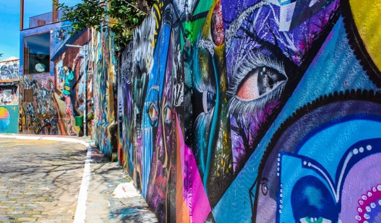 Beco com dezenas de imagens desenhadas nas paredes