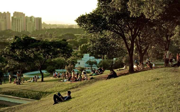 Pessoas sentadas na grama do Parque Ibirapuera
